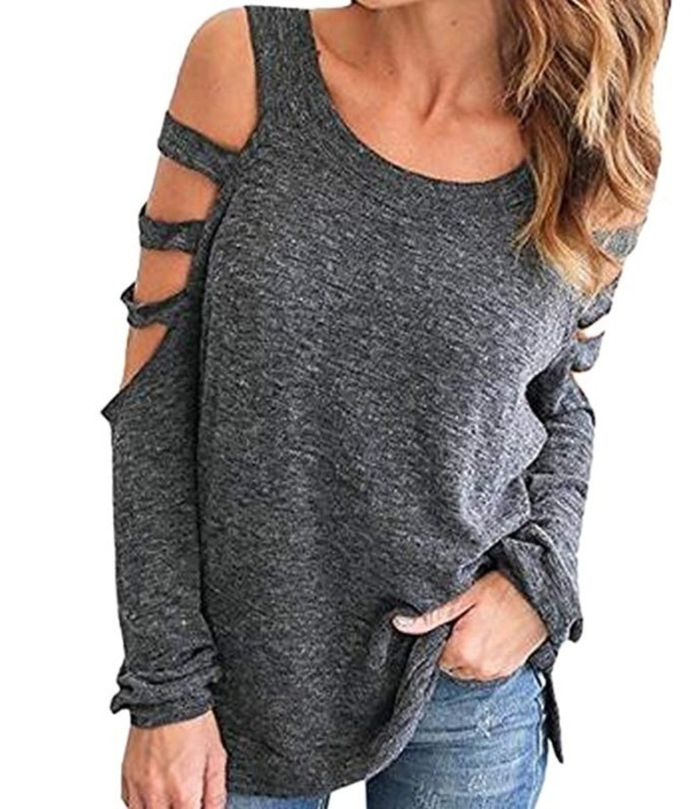 Close-up view of a charcoal grey long sleeve top featuring cold shoulder cutouts and triple strap sleeve detail, styled with blue jeans for a casual yet edgy everyday outfit.