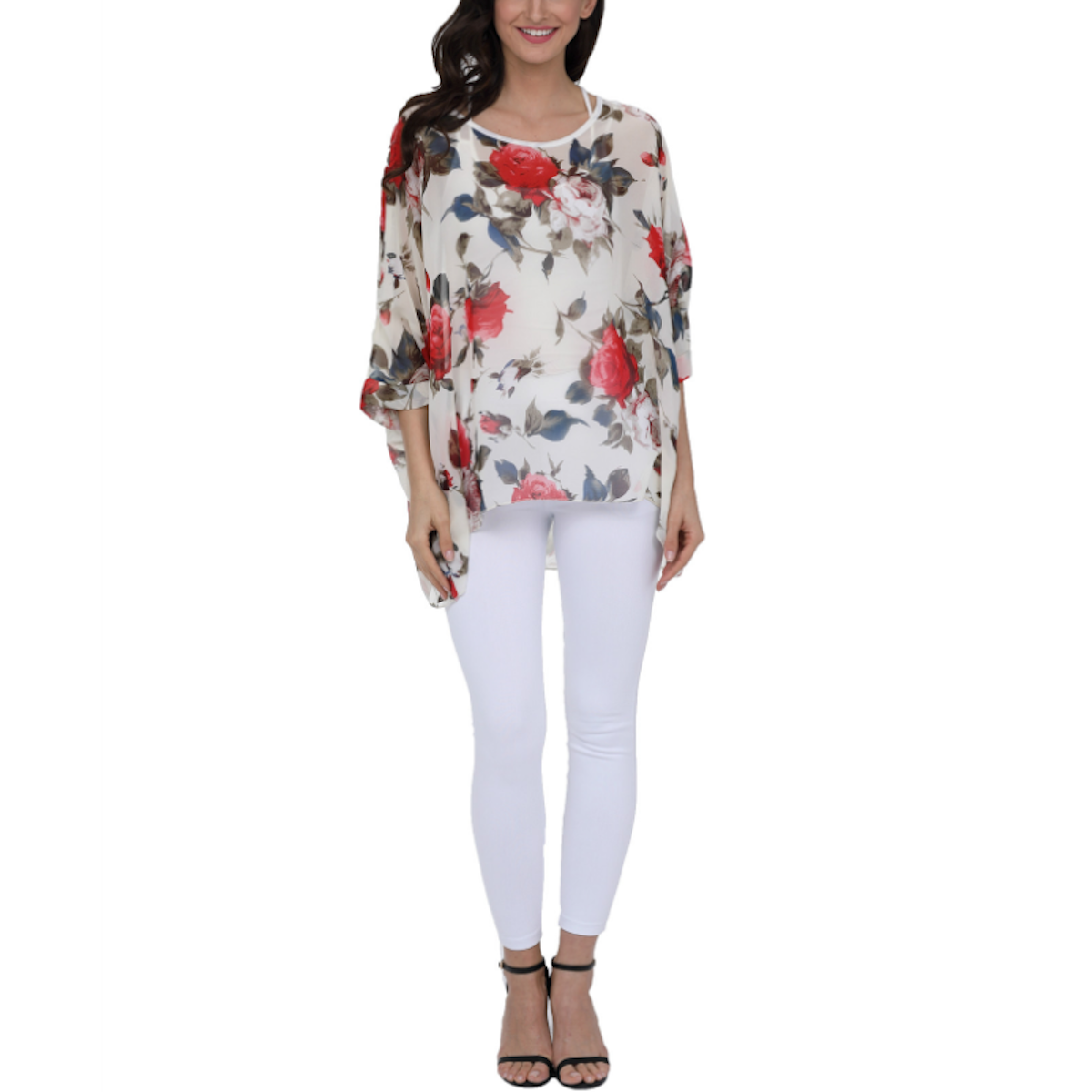 Woman wearing a white chiffon blouse with red and pink floral print paired with white skinny trousers and black heels, showcasing a stylish spring or summer casual outfit.