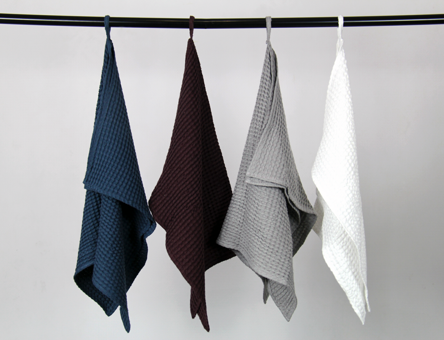 Set of four hanging waffle weave cotton towels in dark teal, burgundy, light grey, and white — breathable, fast-drying, and ideal for kitchen or bathroom use