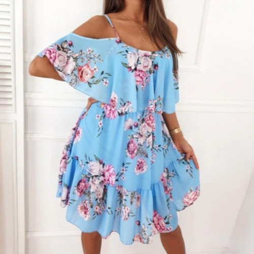 Woman wearing a sky blue off-shoulder midi dress with pink and white floral print, featuring ruffle overlay and adjustable spaghetti straps.