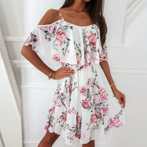 Woman wearing a white midi dress with pink rose floral print, cold shoulder design, and layered ruffle detail over the bodice.