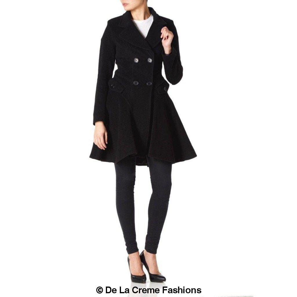 Model wearing a black double-breasted fit and flare wool coat by De La Creme Fashions – tailored winter outerwear with flared hem and button detailing
