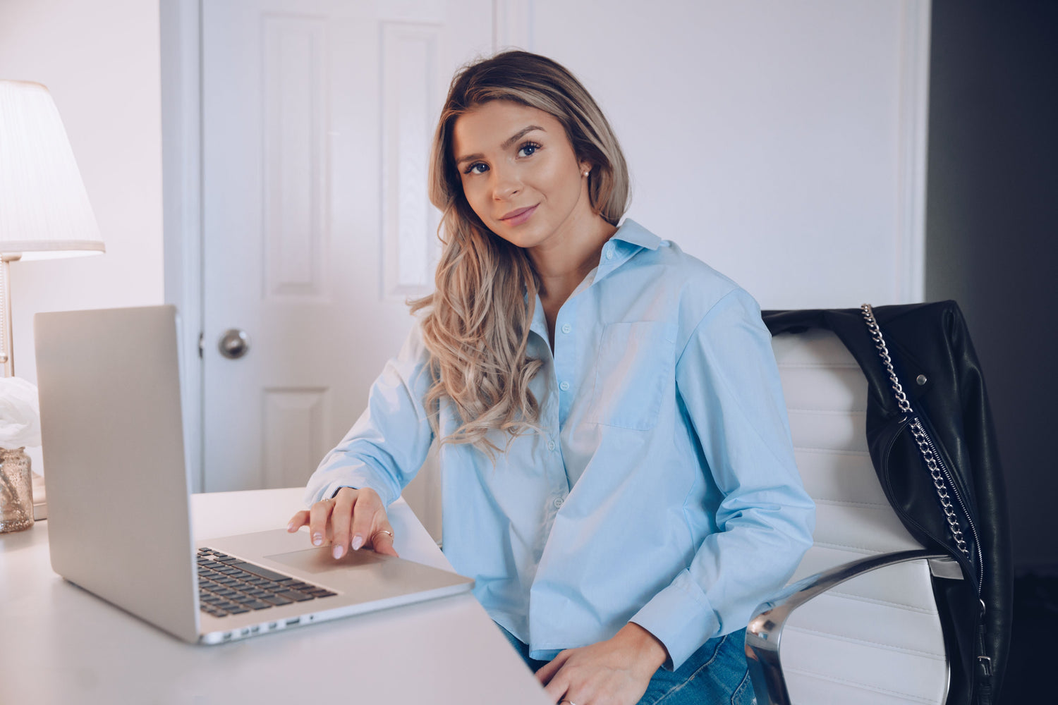 Woman working at laptop in a bright home office, symbolising comfort, focus, and modern workspace wellbeing