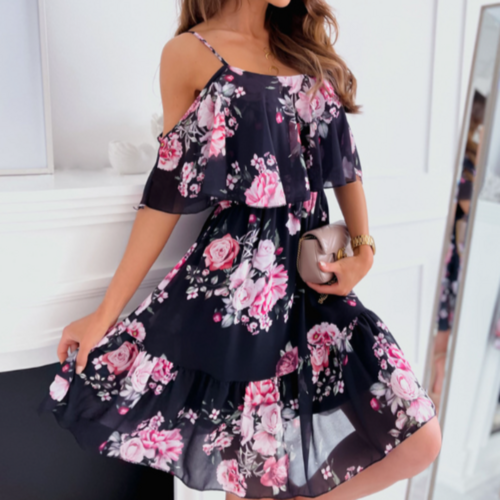 Woman in a navy blue midi dress with pink and white floral print, featuring cold shoulder cutouts and layered ruffle bodice design.