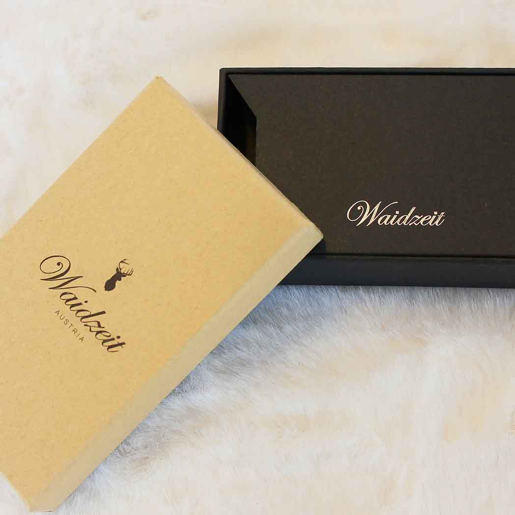 Elegant Waidzeit Austria branded packaging with a tan outer box and black inner box, displayed on a soft fur surface—ideal for presenting wooden watches or straps.