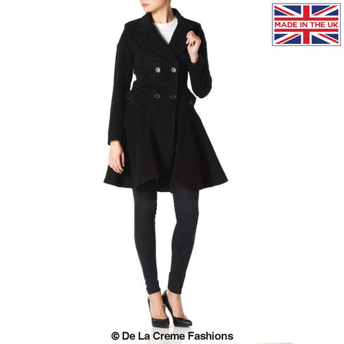Woman wearing black fit and flare double-breasted wool-blend coat with buttoned pockets, made in the UK by De La Creme Fashions.
