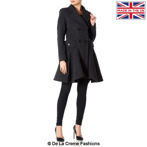 Model wearing a charcoal grey fit and flare wool-blend coat with double-breasted buttons and flared hem, tailored by Mimi London, made in the UK – De La Creme Fashions.